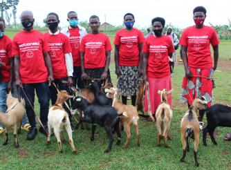 Graduates posing in a group photo holding AAR gift of goats